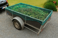 Toepassingsfoto aanhangernet met randkoord en ingeweven elastiekkoord bevestigd op een aanhangwagen met tuinafval