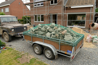 Toepassingsfoto aanhangernet met randkoord en ingeweven elastiekkoord bevestigd op een aanhangwagen met steenpuin