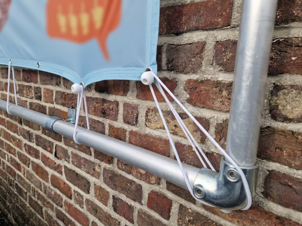 Reclamedoek bevestigen in een frame met spanelastiek met bol