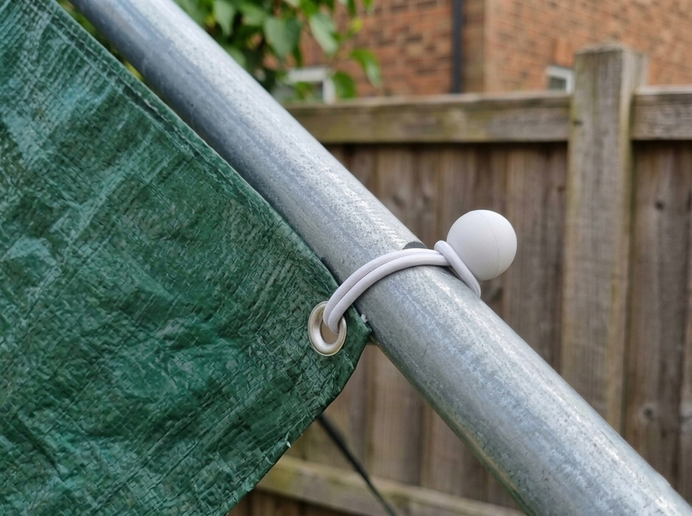 Zeil bevestigen aan een paal met een elastische spanner met bol